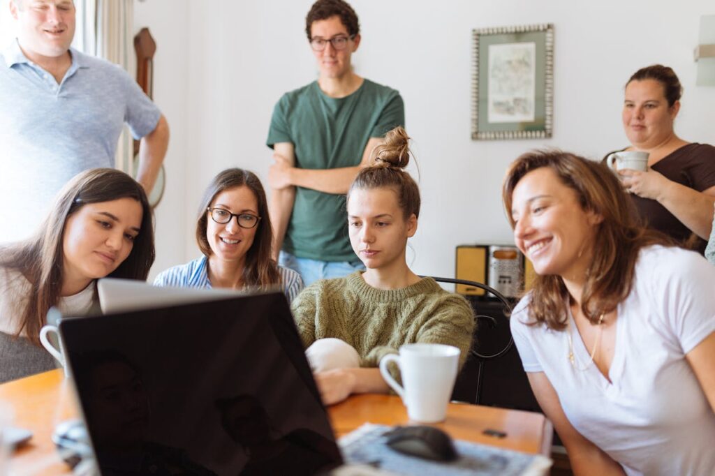 pexels photo 1595391 A diverse group of adults at work, enjoying a casual meeting indoors with focus and smiles.